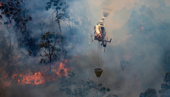 helicopter bearing water over fire