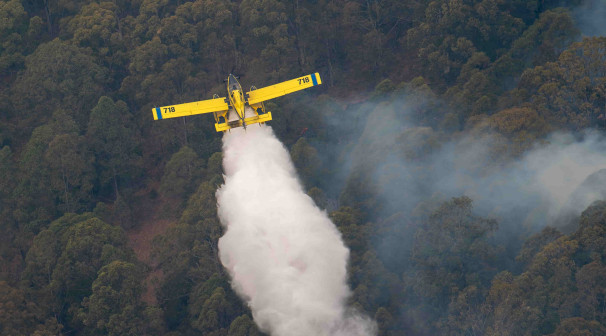 yellow airplane releasing water