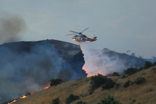helicopter releasing water on fire